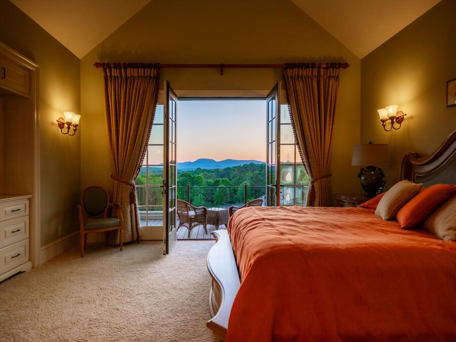 Primary bedroom at dusk with the balcony doors open